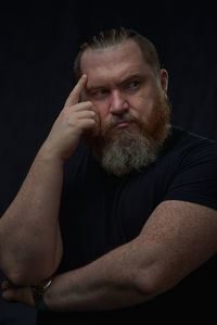 Portrait of senior man against black background