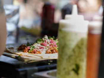 Tortilla with green sauce, parsley, kebab and raw meat