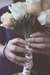 Midsection of woman holding rose bouquet