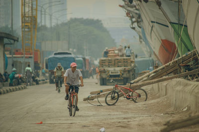 People riding bicycle on street in city at port of sunda kelapa