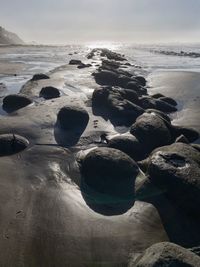 Rocks on beach against sky