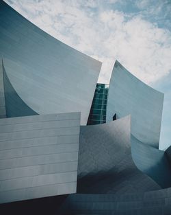 Low angle view of modern building against cloudy sky