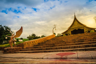 View of temple on building against cloudy sky