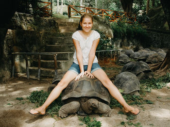 Woman sitting on the giant tortoise