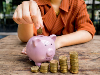Close-up of hand holding coins on table