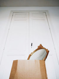 Low angle view of white door on wooden wall at home