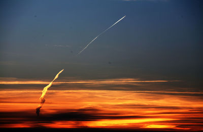 Scenic view of vapor trails against sky during sunset