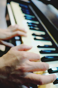 Cropped hands of man playing piano