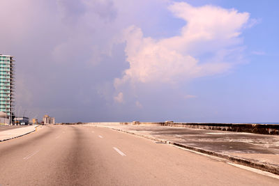 Empty road in city against sky