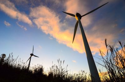 Low angle view of windmill on field against sky