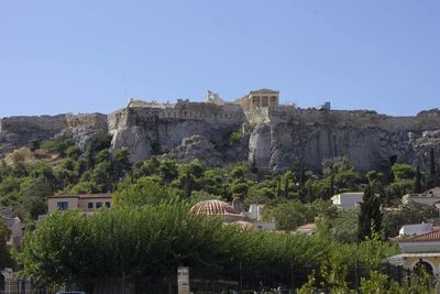 Buildings in city against clear blue sky