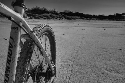 Cropped bicycle parked at sandy beach