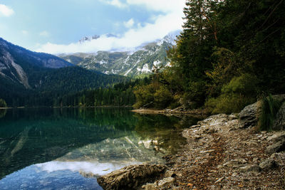 Scenic view of lake by mountains against sky