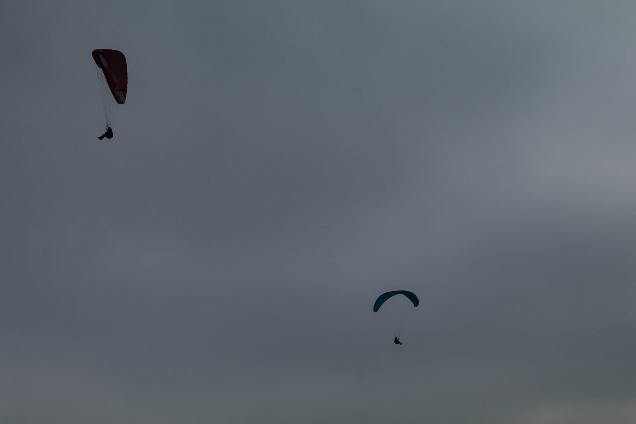 LOW ANGLE VIEW OF SILHOUETTE PEOPLE FLYING AGAINST SKY