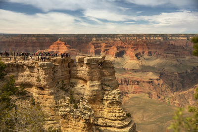 Rock formations on landscape against cloudy sky