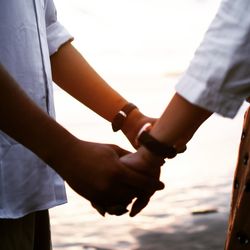 Midsection of couple holding hands