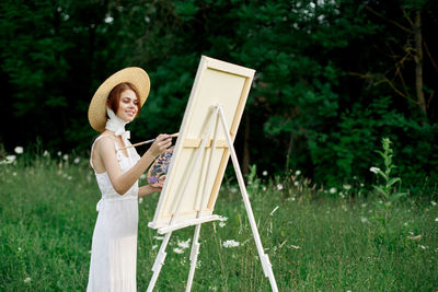 Woman holding umbrella against plants