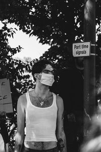 Portrait of young man standing against sign