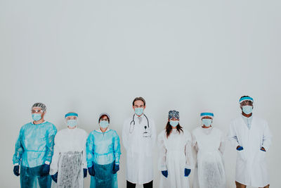 Doctors wearing mask standing against white background