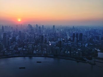 Aerial view of city lit up at sunset