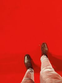 Low section of man standing on red carpet