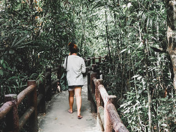 Rear view of woman walking in forest