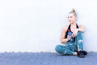 Portrait of cute girl sitting on footpath