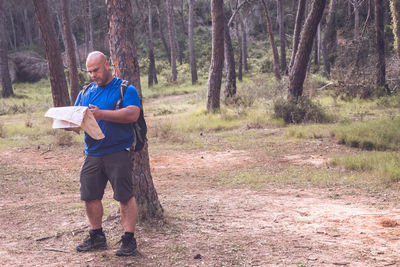 Hiker exploring the forest with a paper map.