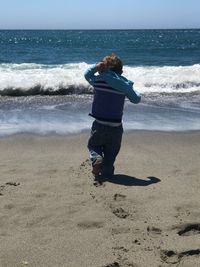 Rear view of boy on beach