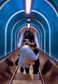 Rear view of couple walking in train