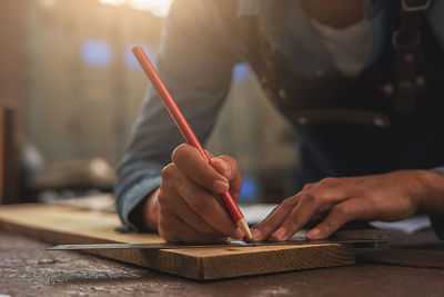 Midsection of man working on table