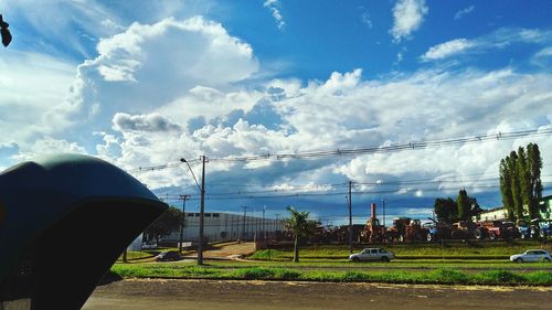 View of green landscape against cloudy sky