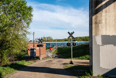 Road by building against sky on sunny day