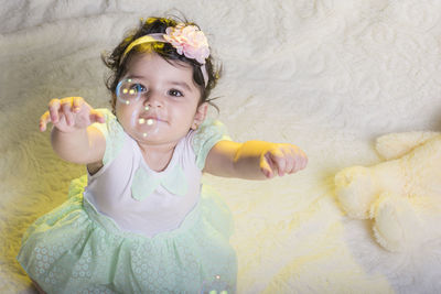 Portrait of cute smiling girl lying on bed