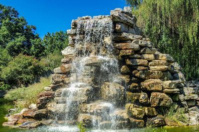 Low angle view of waterfall against clear sky