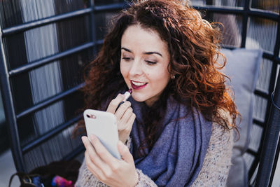 Portrait of smiling young woman using mobile phone