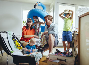 Happy family of five packing for holiday trip