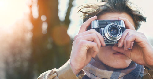 Cropped image of woman holding camera