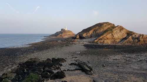 Rock formations by sea against sky