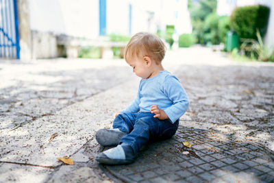 Cute boy looking away while sitting on floor