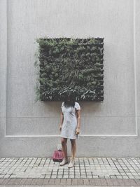 Rear view of woman standing on footpath