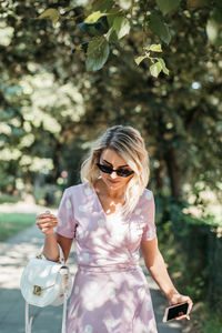 Young woman wearing sunglasses standing on footpath