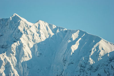 Scenic view of snowcapped mountains against clear sky