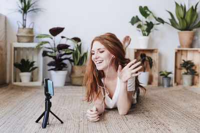 Woman sitting by potted plant