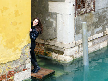 Portrait of woman standing by wall