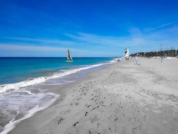 Scenic view of beach against blue sky