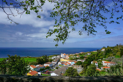 Scenic view of sea by buildings against sky