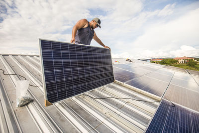 Electrician installs solar panels on rooftop.
