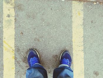 Low section of man standing on road