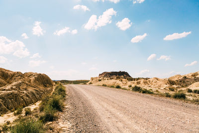 Road amidst desert against sky